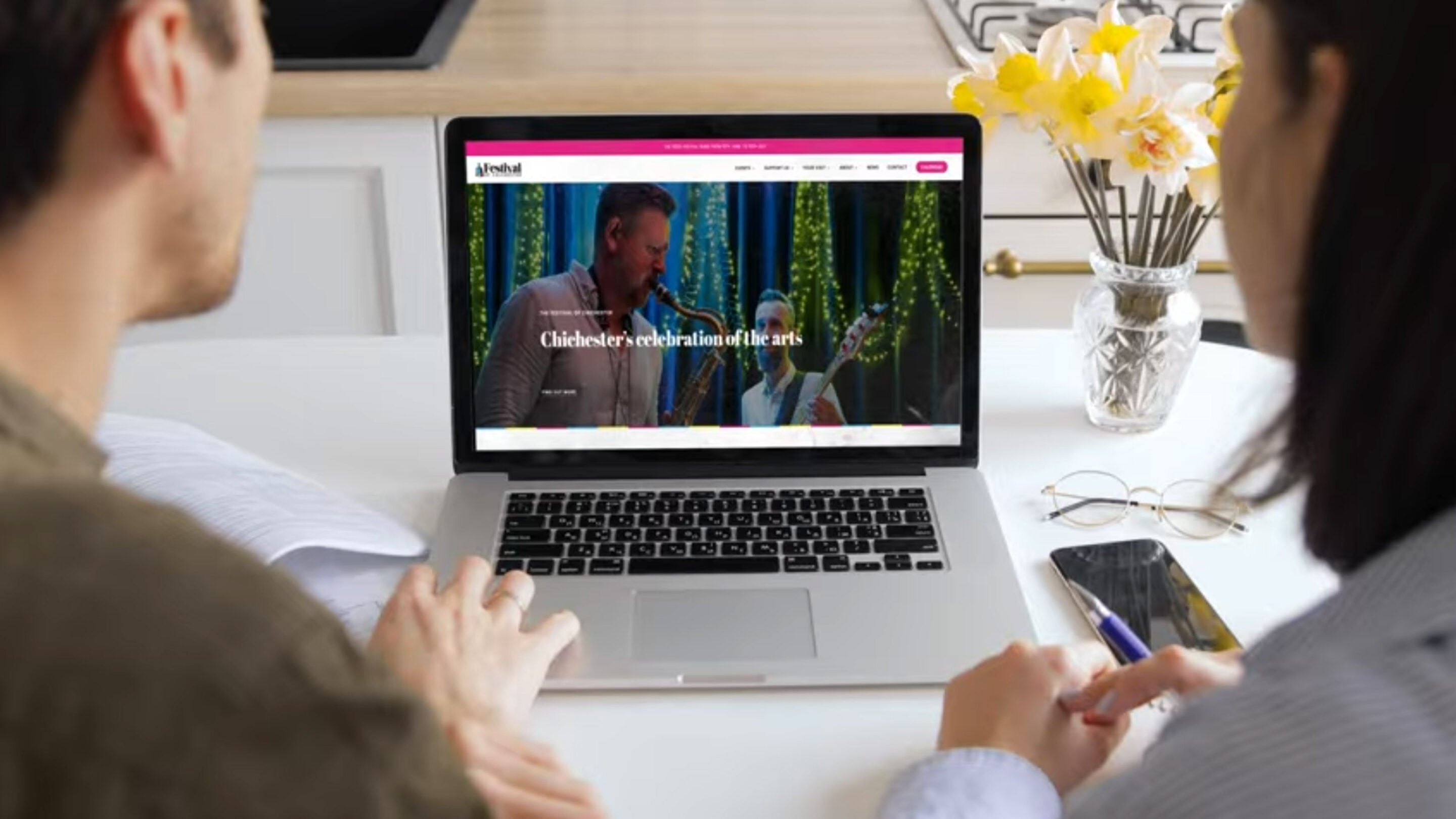 A couple book tickets for Festival of Chichester events on a laptop 